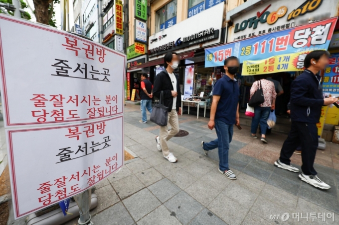 서울 시내의 한 복권방에서 복권을 사려는 시민들로 붐비고 있다./사진=[서울=뉴시스] 김근수 기자