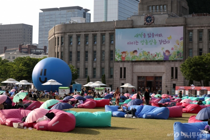 [서울=뉴시스] 김선웅 기자 = 지난달 18일 개장한 '서울야외도서관'이 이른 무더위로 운영 시간대가 2주 앞당겨져 야간으로 변경된다. 서울시는 오늘부터 9월 29일까지 '책 읽는 서울광장', '광화문 책마당'은 오후 4~9시로, 청계천 '책 읽는 맑은냇가'는 정오부터 오후 8시로 운영시간을 변경한다. 17일 서울광장에서 시민들이 독서와 휴식시간을 갖고 있다. 2024.05.17. mangusta@newsis.com /사진=김선웅