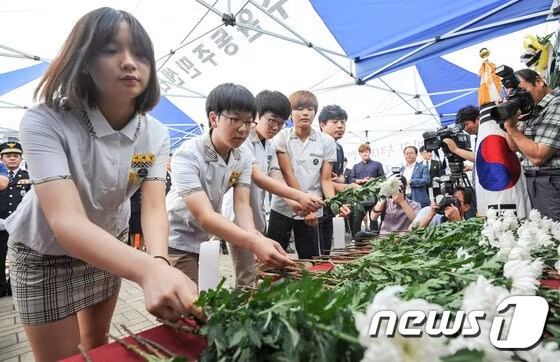 2015년 7월17일 광주 광산구 성덕중학교 인근에서 열린 소방헬기 추락사고 1주기 순직자 추모식에서 성덕중학교 학생들이 헌화를 하고 있다. /사진=뉴스1