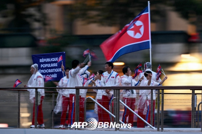  북한 선수단이 27일(한국 시간) 2024 파리 올림픽 개회식이 열린 프랑스 파리 센강에서 보트를 탄 채 수상 행진을 하고 있다. /AFPBBNews=뉴스1 