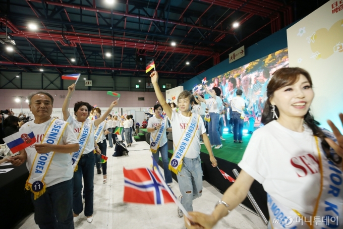 26일 서울 강남구 SETEC에서 열린 '시니어코리아 선발대회'에서 참가자들이 2024 파리올림픽을 응원하는 의미로 만국기를 들고 워킹하고 있다. /사진=김휘선 기자 hwijpg@