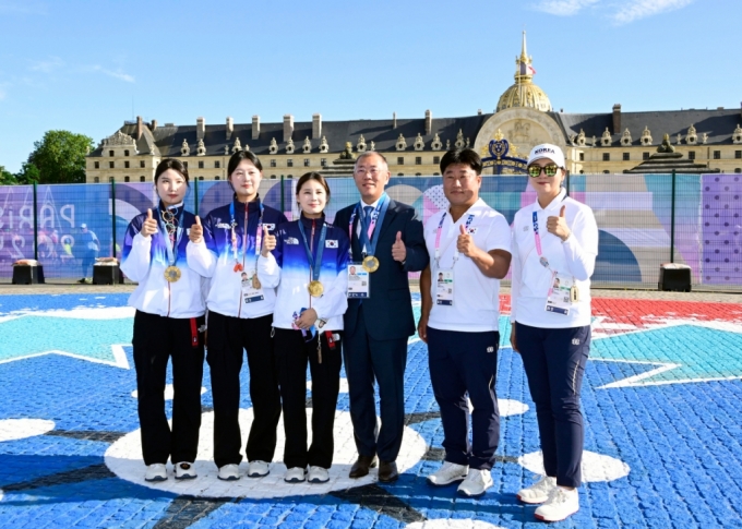 현대차그룹 정의선 회장이 여자 양궁 단체 국가대표 선수들(왼쪽부터 남수현, 임시현, 전훈영), 코치진(왼쪽부터 양창훈 감독, 김문정 코치)과 기념 촬영하는 모습. /사진제공=대한양궁협회