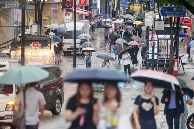 서울 중구 명동 거리에서 우산을 쓴 시민들이 걸음을 옮기고 있다./사진=뉴스1