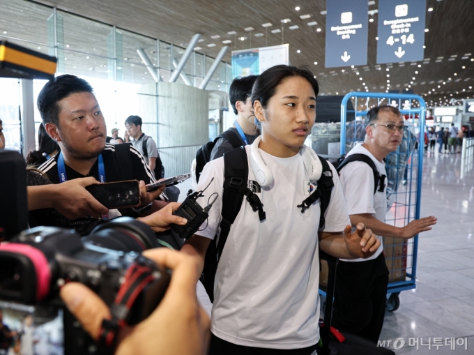 (파리 샤를드골 공항(프랑스)=뉴스1) 이동해 기자 = 2024 파리올림픽 단식에서 금메달을 수확한 배드민턴 국가대표팀 안세영이 7일(한국시간) 프랑스 파리 샤를 드골 공항을 통해 귀국길에 오르며 취재진 질문에 답변하고 있다.   안세영은 지난 5일 허빙자오(중국)을 꺾고 금메달을 획득했지만, 시상식 종료 후 이어진 인터뷰에서 선수 부상 관리의 소홀함 등을 언급하며 협회를 비판했고 더 이상 대표팀과 동행이 어렵다는 폭탄발언을 전했다. 올림픽 일정을 모두 마친 안세영은 배드민턴 대표팀과 함께 파리를 떠나 7일 귀국할 예정이다.   사 /사진=(파리 샤를드골 공항(프랑스)=뉴스1) 이동해 기자