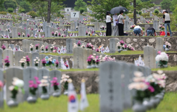 6·25전쟁 74주년을 하루 앞둔 지난 6월24일 서울 동작구 국립서울현충원에서 유가족들이 고인의 묘역을 참배하고 있다./사진=뉴스1