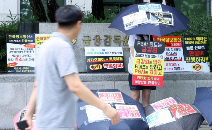 티몬·위메프(티메프) 피해자가 7일 오후 서울 여의도 금융감독원 앞에서 여행상품 환불 지원방안을 촉구하는 릴레이 우산 시위를 진행하고 있다. /사진제공=뉴스1