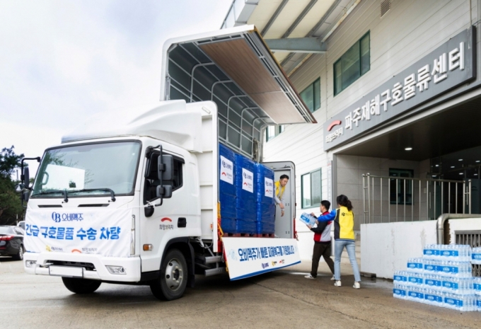 희망브리지 파주 물류센터에서 오비맥주가 기부한 생수를 수송 차량에 싣고 있다./사진제공=오비맥주