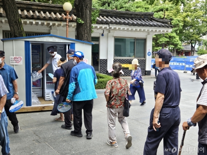 12일 오전 서울 종로구 탑골공원에 무료급식소를 이용하기 위해 온 고령자들에게 아리수를 나눠주고 있다. /사진=정세진 기자 