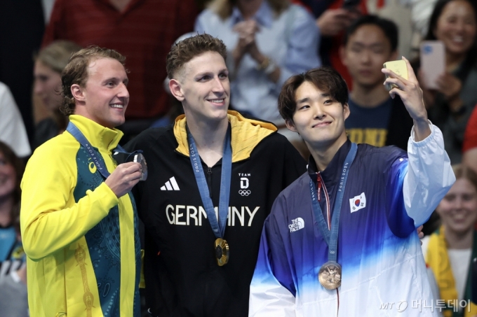 지난달 27일(현지시간) 프랑스 파리 라 데팡스 아레나에서 열린 2024 파리 올림픽 남자 자유형 400m 시상식에서 금메달 루카스 마르텐스(Lukas Martens, 독일), 은메달 일라이자 위닝턴(Elijah Winnington, 호주), 동메달 김우민(대한민국) 선수가 시상대에서 갤럭시 Z 플립6 올림픽 에디션으로 빅토리 셀피를 찍고 있다.  (삼성전자·게티이미지 제공)/사진=뉴스1