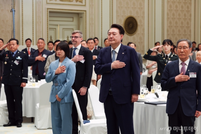 [서울=뉴시스] 최진석 기자 =  윤석열 대통령이 14일 청와대 영빈관에서 열린 독립유공자 후손 초청 오찬에서 독립유공자 후손 등을 비롯한 참석자들과 국기에 경례를 하고 있다. (대통령실통신사진기자단) 2024.08.14. myjs@newsis.com /사진=최진석