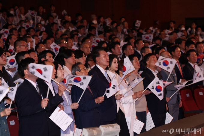 [서울=뉴시스] 조수정 기자 = 윤석열 대통령과 부인 김건희 여사를 비롯한 참석자들이 15일 서울 종로구 세종문화회관에서 열린 제79주년 광복절 경축식에서 태극기를 흔들며  광복절 노래를 제창 하고 있다. 2024.08.15. chocrystal@newsis.com /사진=조수정