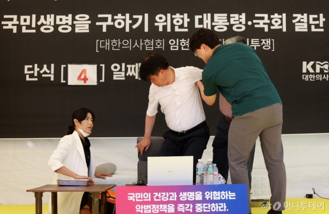 [서울=뉴시스] 이영환 기자 = '국민생명을 구하기 위한 대통령·국회 결단 촉구' 단식투쟁을 4일째 이어가고 있는 임현택 대한의사협회 회장이 29일 오후 서울 용산구 대한의사협회 앞 천막에서 관계자들의 부축을 받고 있다. 2024.08.29. 20hwan@newsis.com /사진=이영환