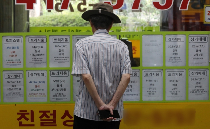 지난달 11일 서울 송파구 부동산중개업소 앞에서 한 시민이 매물 정보를 바라보고있다. /사진=뉴스1.