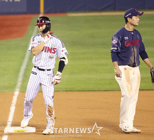 '2024 신한 SOL 뱅크 KBO리그' LG-롯데전이 10일 서울 잠실야구장에서 열렸다.  LG 구본혁이 3회말 무사에서 우중월 3루타를 날리고 3루에 안착한 후 세리머니를 선보이고 있다. 오른쪽은 올시즌 LG에서 이적한 롯데 3루수 손호영.