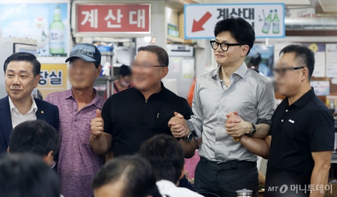 한동훈 국민의힘 대표가 11일 부산 금정구 서동미로시장에서 돼지국밥 식당을 찾아 시민들과 기념사진을 찍고 있다. 2024.9.11/뉴스1  Copyright (C) 뉴스1. All rights reserved. 무단 전재 및 재배포,  AI학습 이용 금지. 