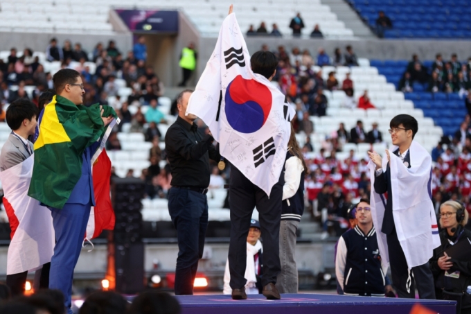 2024 프랑스 국제기능올림픽에 출전한 한국 선수가 15일(현지시간) 리옹 그루파마 스타디움에서 열린 시상식에서 금메달을 수상하며 손을 번쩍 들어올리고 있다. /사진제공= 국제기능올림픽대회 조직위원회