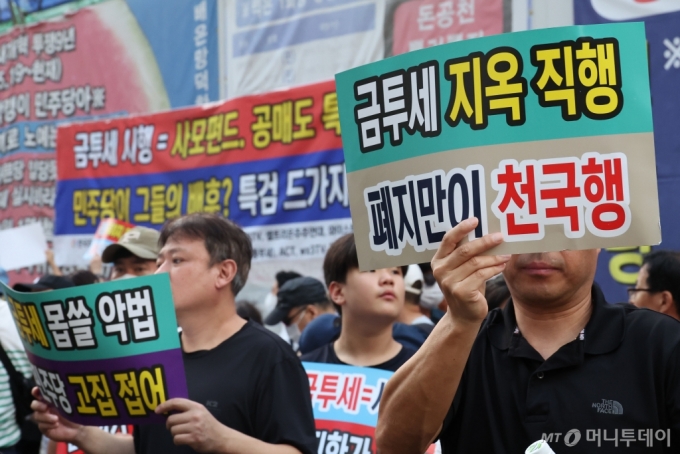 한국주식투자자연합을 비롯한 12개 투자자 단체 회원들이 15일 오후 서울 여의도 더불어민주당 당사 앞에서 열린 금투세 폐지 촉구 집회에서 금투세 폐지 손피켓을 들고 있다. 2024.08.15./사진=뉴시스