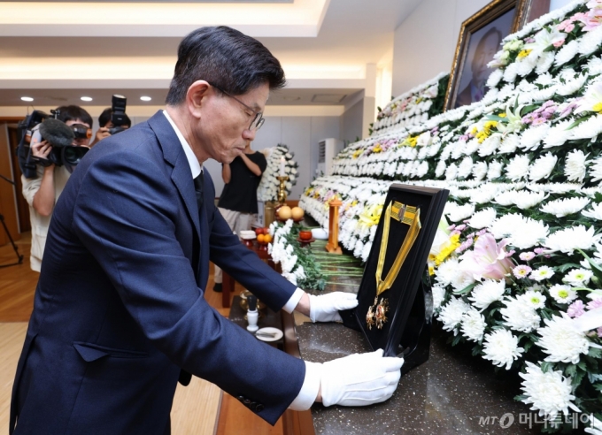 [서울=뉴시스] 정병혁 기자 = 김문수 고용노동부 장관이 22일 서울 종로구 서울대학교병원 장례식장에 마련된 고 장기표 신문명정책연구원 원장 빈소에서 국민훈장 모란장을 추서하고 있다. (공동취재) 2024.09.22. photo@newsis.com /사진=