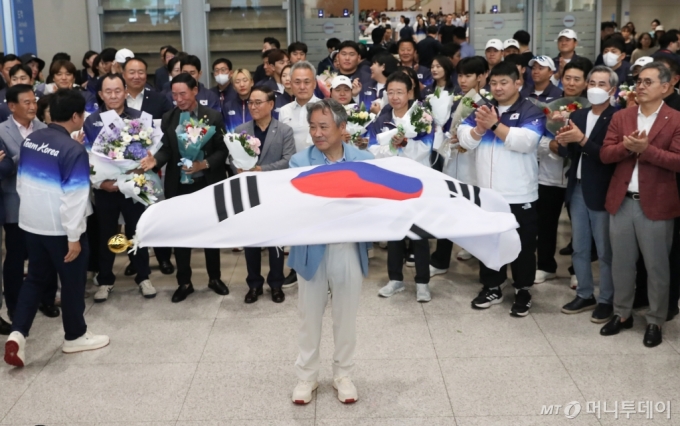 (인천공항=뉴스1) 이승배 기자 = 이기흥 대한체육회장이 파리 올림픽을 마치고 13일 인천국제공항을 통해 귀국해 태극기를 흔들고 있다.