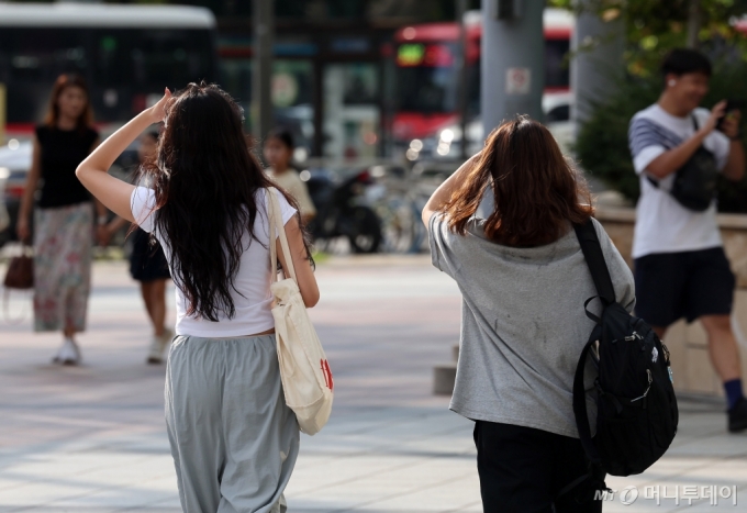 [서울=뉴시스] 김명년 기자 = 서울에 폭염경보가 내려진 18일 오후 서울 송파구 잠실네거리에서 시민들이 손바닥으로 햇빛을 가린 채 이동하고 있다. 2024.09.18. kmn@newsis.com /사진=김명년