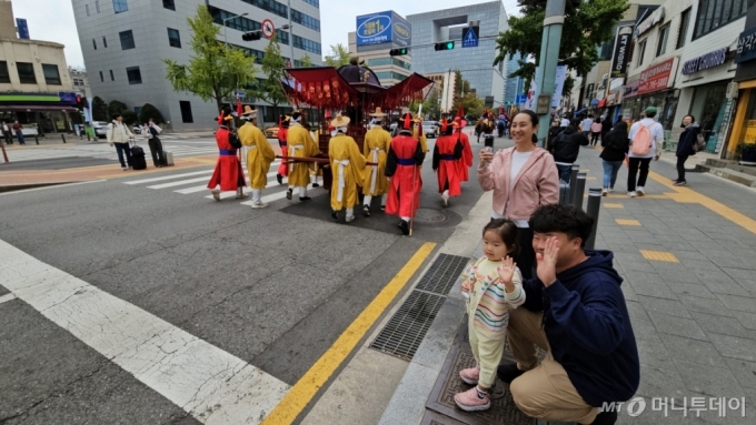 6일 오전 서울 용산구 한강대로 노들섬 방향 차로에서 정조대왕 능행차 재현 행사 참가자들이 행진하고 있다. 세종시에 사는 서규진씨(42·남)는 이날 딸 지윤양(4)과 아내와 함께 행렬을 구경했다. 사진은 행렬을 향해 손을 흔드는 지윤양과 규진씨. /사진=정세진 기자 