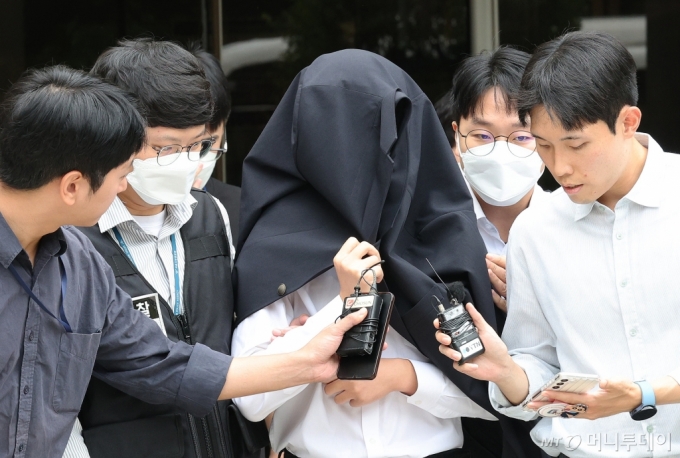 의료계 집단행동에 동참하지 않은 의사·의대생의 신상 정보가 담긴 블랙리스트 '감사한 의사'를 유포한 사직 전공의 정 모씨가 20일 서울 서초구 서울중앙지법에서 열린 구속 전 피의자 심문(영장실질심사)을 마친 뒤 경찰과 함께 이동하고 있다/사진=(서울=뉴스1) 장수영 기자