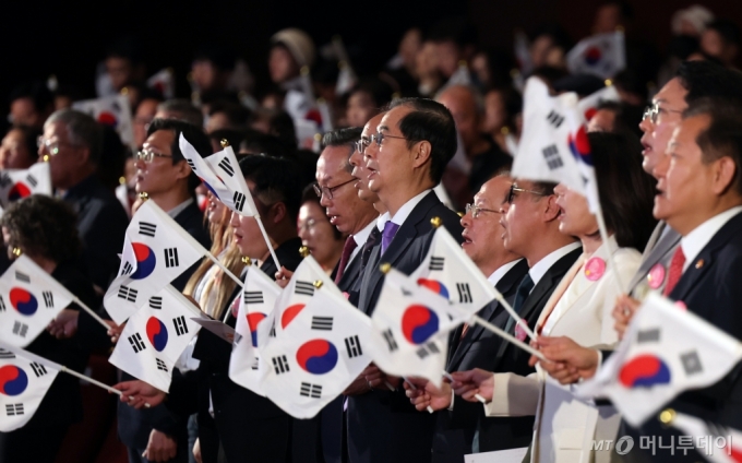 (서울=뉴스1) 황기선 기자 = 한덕수 국무총리가 9일 오전 서울 종로구 세종문화회관에서 열린 &#039;제578돌 한글날 경축식&#039;에서 태극기를 들고 한글날 노래를 제창하고 있다. 2024.10.4/뉴스1