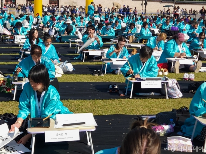 한국예술문화원이 주최한 이날 행사에는 총 300명이 참가했다. 고사리손으로 붓을 잡은 어린이부터 나이가 지긋한 어르신까지 남녀노소가 자리를 채웠다. 프랑스·영국·멕시코·케냐·우크라이나·이란·네팔·일본 등 각국에서 온 외국인 참가자도 50명에 달했다. 참가자들은 조선시대 과거시험을 연상시키듯 모두 옥색 두루마기를 걸치고 있었다./사진=최지은 기자