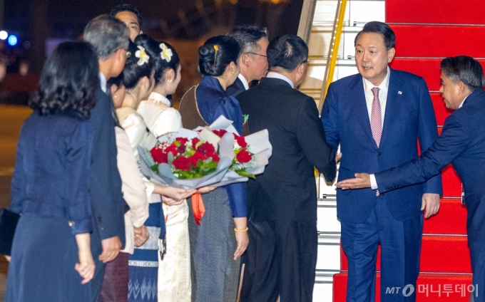 [비엔티안=뉴시스] 최진석 기자 = 아세안(ASEAN·동남아시아국가연합) 정상회의 참석차 라오스를 방문한 윤석열 대통령이 9일(현지시각) 비엔티안 왓타이 국제공항에 도착해 환영 인사들과 인사를 나누고 있다. 2024.10.09. myjs@newsis.com /사진=최진석