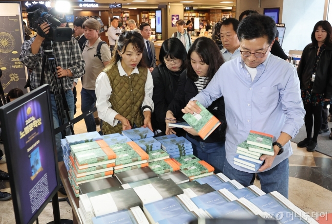 (서울=뉴스1) 김진환 기자 = 11일 서울 종로구 교보문고을 찾은 시민들이 노벨문학상을 수상한 작가 한강의 책을 구매하고 있다.   스웨덴 한림원은 지난 10일 소설가 한강이 노벨문학상 수상자로 선정됐다고 발표했다. 한국인의 노벨상 수상은 2000년 고(故) 김대중 대통령의 평화상 수상에 이어 두 번째이며, 아시아 작가 수상은 2012년 중국 작가 모옌 이후 12년 만이다.   스웨덴 한림원은 선정 이유로 "역사적 트라우마에 맞서고 인간의 삶의 연약함을 드러낸 강렬한 시적 산문"이라고 꼽았다. 2024.10.11/뉴스1 /사진=(서울=뉴스1) 김진환 기자