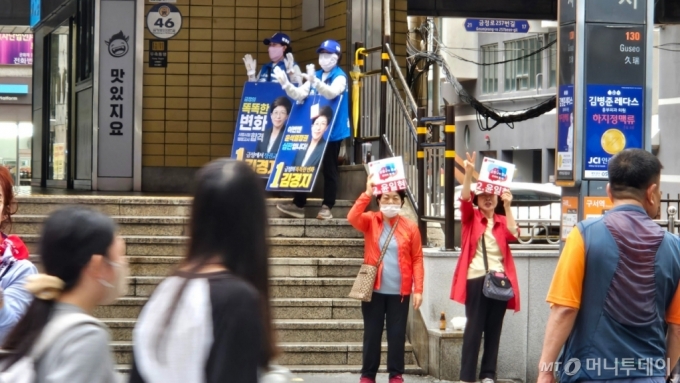 15일 부산 금정구 구서역 앞. 김경지 더불어민주당 후보와 윤일현 국민의힘 후보를 지지하는 선거봉사자들이 각각 후보 지지를 호소하고 있다./사진=박상곤 기자