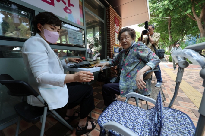 지난 5월 서울 마포구 효도밥상경로당에서 열린 주민참여 효도밥상 제공 행사에서 어르신들이 식사에 앞서 건강검진을 하고 있다. /사진= 뉴시스