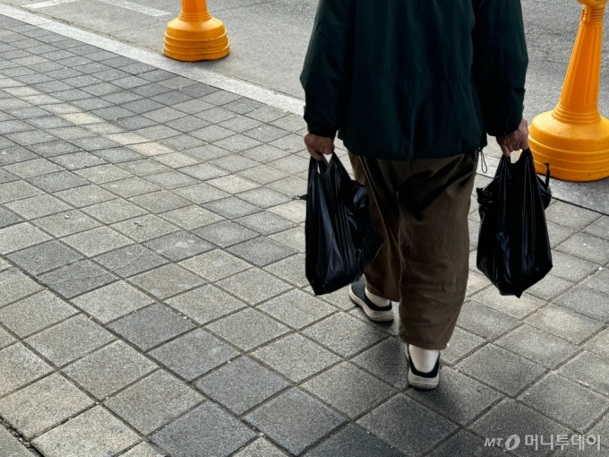 시장을 찾은 소비자들은 오른 전어 가격이 부담이라고 했다. 1㎏당 2만~2만5000원 정도였던 전어는 올해 4만원으로 올랐다. 한 소비자가 수산물을 구매한 뒤 노량진 수산물 도매시장을 나서는 모습.사진=김호빈 기자