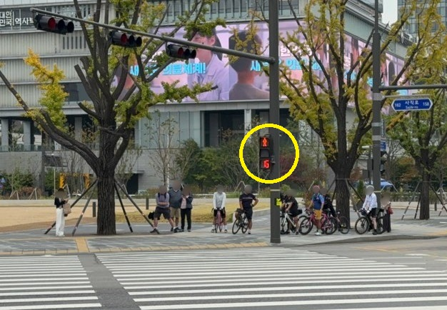 서울 광화문 일대에 설치된 적색 잔여 시간 표시 신호등. 시민들이 남은 대기 시간을 보며 횡단보도 앞에서 기다리고 있다. /사진=김선아 기자