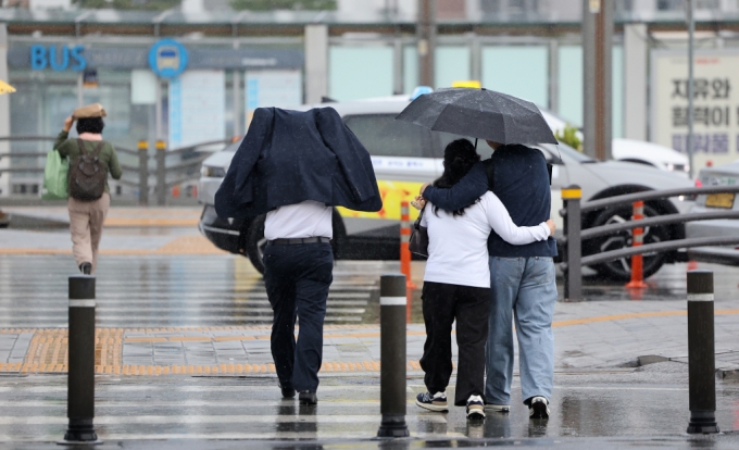 대구 동대구역 인근에서 우산을 준비하지 못한 한 시민이 옷으로 비를 피하며 이동하고 있다./사진=뉴시스