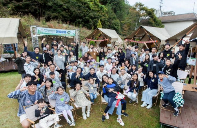  SK케미칼은 용인시 처인구에 위치한 캠핑장에서 문화의 날을 맞이해 ‘보통의 삶을 선물하다-캠핑살롱’을 개최했다. 봉사활동에 참여한 SK 구성원들과 가족이 기념사진을 촬영하고 있다.