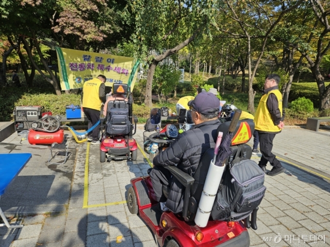 21일 서울 강서구 방화동 방화근린공원에서 열린 '제21회 장애인 어울림한마당'에서 케어 곰두리 봉사회가 전동휠체어 세척 봉사를 하고 있다.  /사진=정세진 기자 