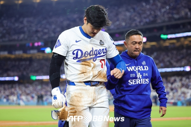 오타니 쇼헤이(왼쪽)가 27일(한국시간) 열린 2024 MLB 월드시리즈 2차전에서 7회 도루하다가 왼 어깨 부상을 당한 뒤 그라운드를 빠져나가고 있다. /AFPBBNews=뉴스1