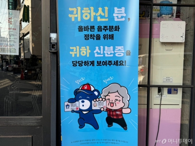 12일 오후 서울 마포구 홍대입구역 근처 한 술집에 신분증 제시를 요구하는 안내문이 붙어 있다. /사진=김호빈 기자