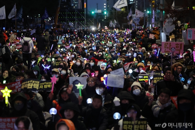  윤석열 대통령에 대한 국회의 2차 탄핵소추안 표결을 하루 앞둔 13일 오후 서울 영등포구 여의도 국회 앞에서 열린 &#039;윤석열 즉각 탄핵 구속 촉구 촛불문화제&#039;에서 참가자들이 응원봉과 손팻말을 들고 있다. /사진=뉴스1 