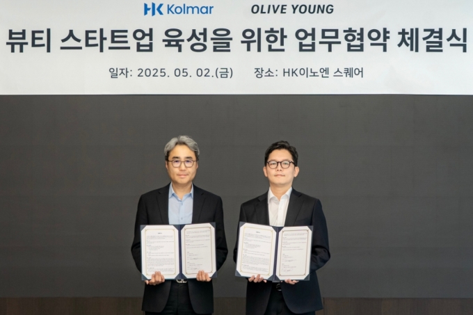 허현행 한국콜마 경영기획본부장(사진에서 왼쪽)과 장지민 CJ올리브영 경영지원담당이 MOU 행사 중 기념 사진을 찍고 있는 모습./사진제공=올리브영
