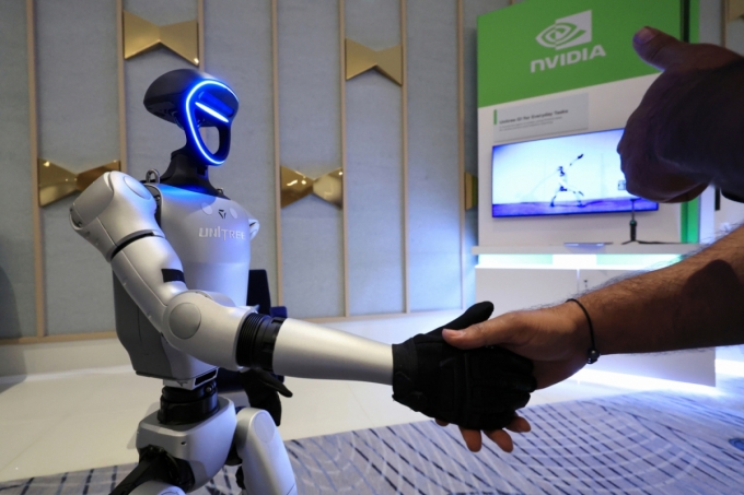 세계 최대 가전·정보기술(IT) 전시회 CES 2025 개막일인 7일(현지시간) 젠슨 황 엔비디아 최고경영자(CEO) 글로벌 기자간담회가 열린 미국 네바다주 라스베이거스 퐁텐블루 호텔에 마련된 엔비디아 전시관에서 휴머노이드 로봇 유니트리 G1이 관람객과 악수하고 있다. (공동취재) 2025.1.8/뉴스1  