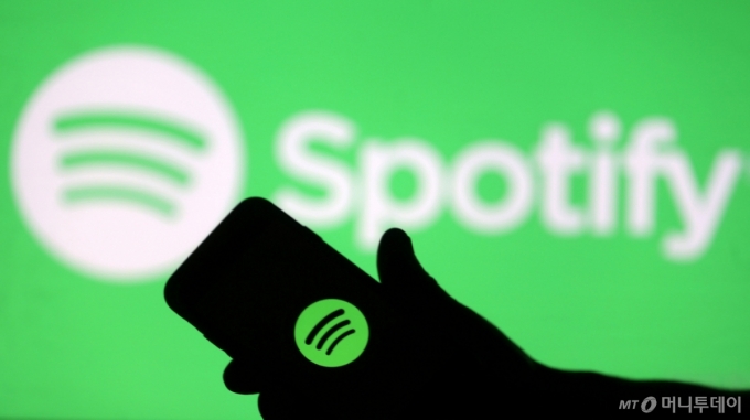 smartphone is seen in front of a screen projection of Spotify logo, in this picture illustration taken April 1, 2018. REUTERS/