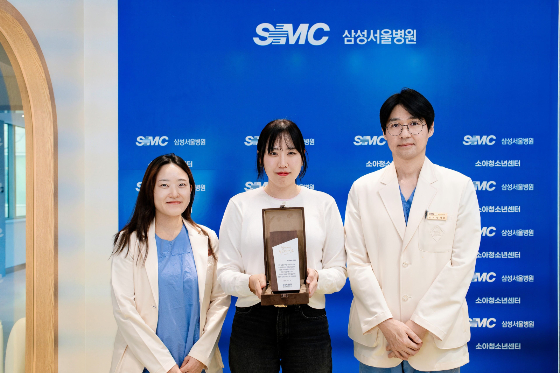 나주영 미닉스 BO(가운데)가 삼성서울병원 소아청소년센터에서 진행된 기부금 전달식에 참여해 기념 촬영을 하고 있다. /사진 제공=앳홈