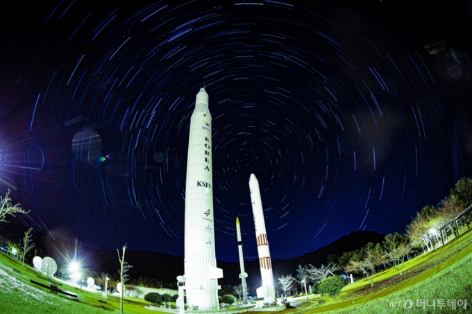 [한국형 발사체 누리호 4차 발사가 성공하며 민간이 제작&middot;조립을 맡은 발사체가 처음으로 정상 임무를 수행했다.   누리호 4차 발사는 한국형 발사체 최초의 야간비행이자 역대 최다인 13기의 위성이 탑재됐다. 나로우주센터 우주과학관 로켓광장에 우리나라에서 개발된 1단형 고체추진 로켓 KSR-Ⅰ, 2단형 고체추진로켓 KSR-Ⅱ, 액체추진 과학로켓 KSR-Ⅲ, 우주발사체 KSLV-Ⅰ(나로호)의 실물크기 로켓 모형 뒤로 별의 일주운동 궤적이 보이는 모습. (별의 일주운동 궤적은 30초로 2시간 촬영 후 각각의 사진 레이어 합성) 2025.12.30./사진=뉴시스