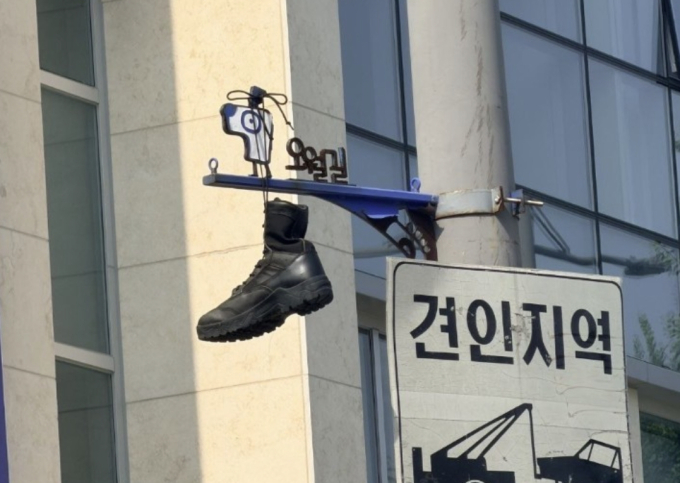 오월길 안내 표지판에 걸린 군화 한 짝…5·18 폄훼 의도 조사
