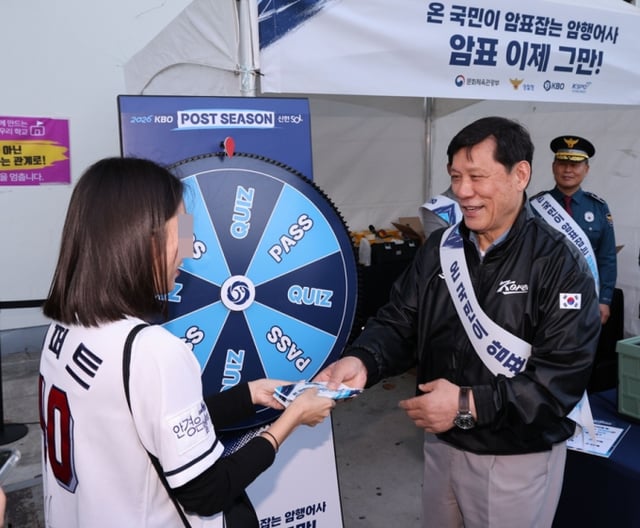 Хё Гу Ён (справа), президент KBO, объясняет фанатам кампанию по искоренению спекуляции билетами на стадионе Чамсиль, где 14-го числа проходил первый матч дикой карты. /фотография=KBO