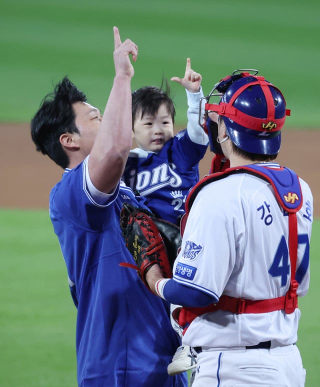 Второй матч плей-офф (PO) постсезона KBO 2026 года, встреча «Самсунг» против KIA, состоялся 27-го числа на стадионе Тэгу Самсунг Лайонс Парк. Легенда «Лайонз», чей номер выведен из обращения, вечный «Король концовок» О Сын Хван после первого броска в надежде на победу «Самсунга», совершённого вместе с сыном, проводит церемонию с кэтчером Кан Мин Хо. /Фото: Ким Чжингён kim.jinkyung@