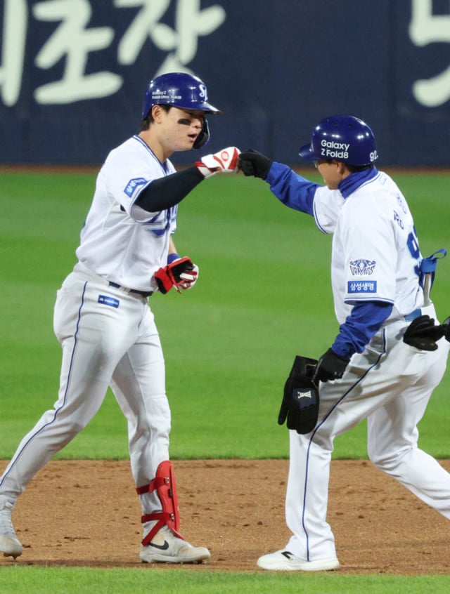 Пак Сонгу (слева) из Samsung Lions обменивается похлопыванием с тренером Чон Пён Конем после того как 27-го числа во втором матче плей-офф против KIA Tigers забил двухбазовый хит, сравнявший счёт в конце третьего иннинга. /Фото: предоставлено Samsung Lions