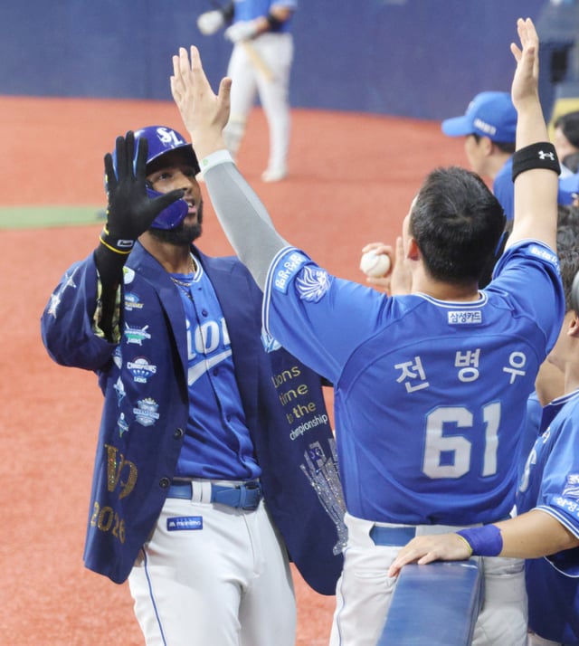Матч между «Киум Хироуз» и «Самсунг Лайонз» в рамках postseason KBO 2026 Shinhan SOL состоялся 25-го числа на Gocheok Sky Dome в Сеуле. Диас из «Самсунга» после того как в начале 4-го иннинга при двух аутах отправил мяч на хоум-ран в правый центральный сектор против стартового питчера «Киума» Алькантары, празднует возвращение на домашнюю базу, встречаясь с приветствиями Чон Пён У. /Фото: Ким Чжингён kim.jinkyung@